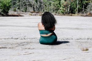 Woman sitting with back to camera on beach